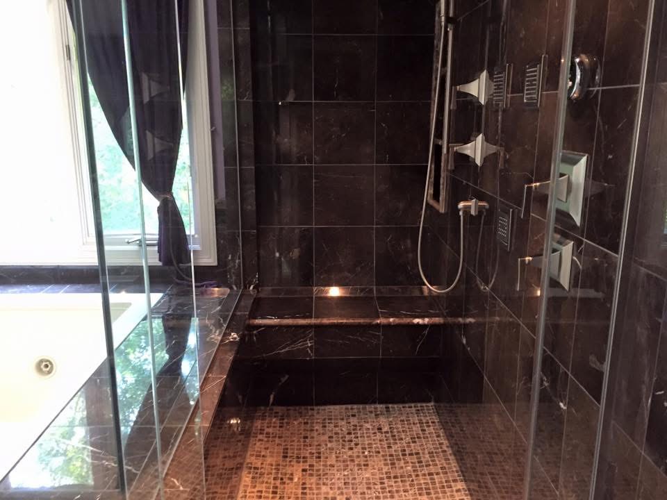 Polished dark marble walk-in shower after a deep cleaning