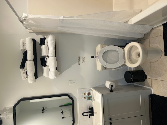Freshly cleaned guest bathroom with folded towels and polished fixtures