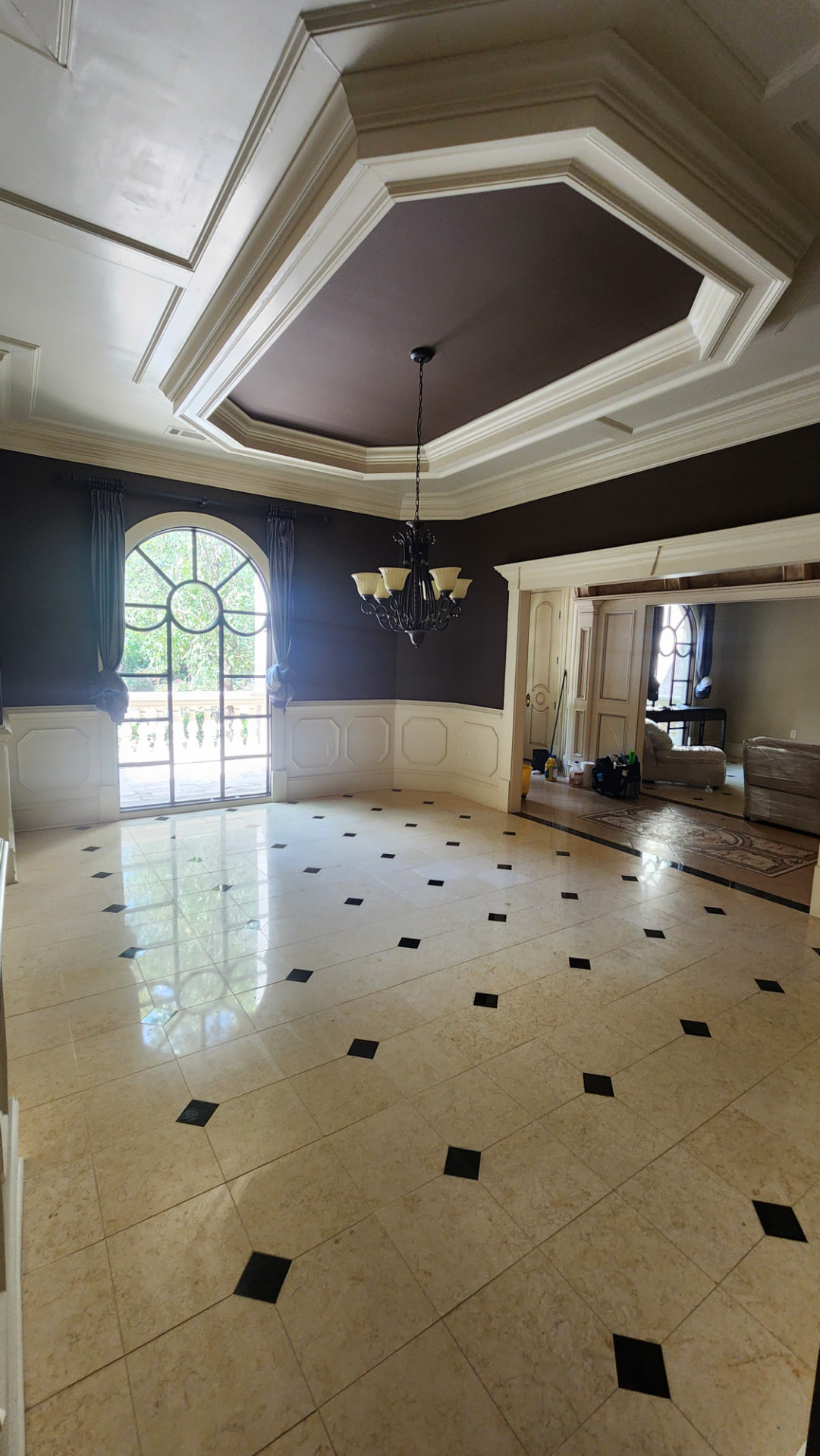 Formal dining room with polished marble tile floors and a coffered ceiling after cleaning